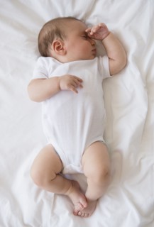 Baby girl (2-5 months) sleeping in bed.
Photo : Jamie Grill