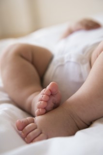 Feet of baby girl (2-5 months) lying in bed.
Photo : Jamie Grill