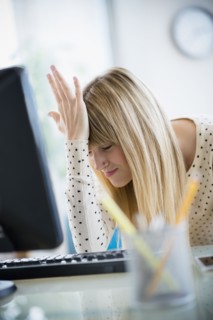 Woman suffering from headache in office.
Photo : Jamie Grill