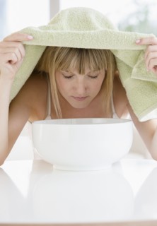 Woman inhaling steam from bowl.
Photo : Jamie Grill