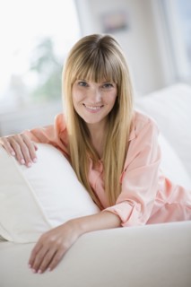 Portrait of woman sitting on sofa.
Photo : Jamie Grill