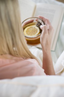Woman holding tea cup and reading book.
Photo : Jamie Grill