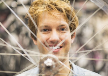 Portrait of man behind bike wheel.
Photo : Daniel Grill