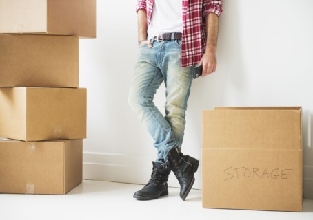 Low section of man next to stack of cardboard boxes.
Photo : Daniel Grill