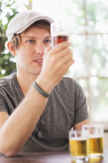 Man looking at glass of beer.
Photo : Daniel Grill