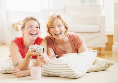 Mother and adult daughter relaxing at home, watching tv.
Photo : Daniel Grill