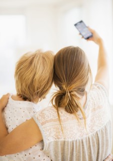 Mother and adult daughter taking self-portrait with smartphone.
Photo : Daniel Grill