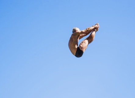 Athletic swimmer mid-air against blue sky.
Photo : Daniel Grill