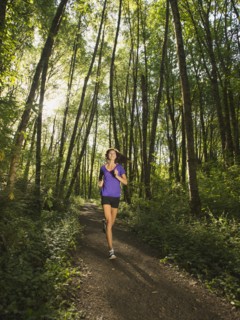 Young woman jogging in forest. USA, Oregon, Portland.