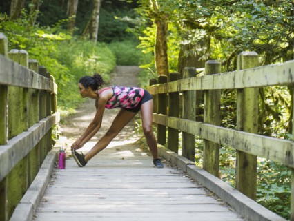 Young women stretching on footbridge. USA, Oregon, Portland.