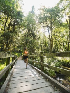Young woman jogging on footbridge. USA, Oregon, Portland.