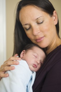 Portrait of mother holding newborn baby (0-11 months).