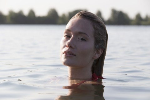 Woman relaxing in lake, Looking at camera. Netherlands, Gelderland, De Rijkerswoerdse Plassen