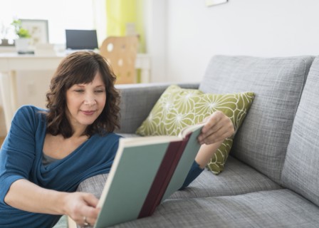Woman reading book at home.
