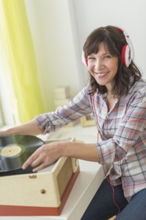 Woman listening to music on antique record player.