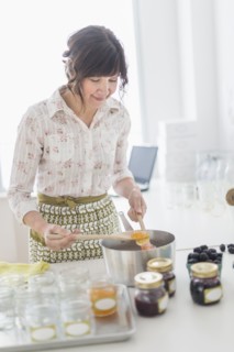 Woman making preserves in kitchen.