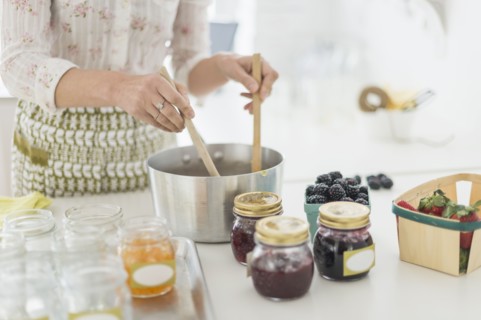 Midsection of woman making preserves in kitchen.