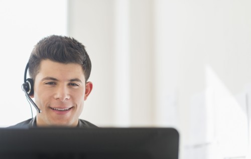 Young man sitting in front of desk and talking.