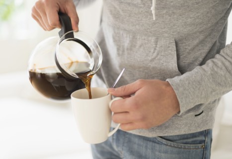 Young man pouring coffee.