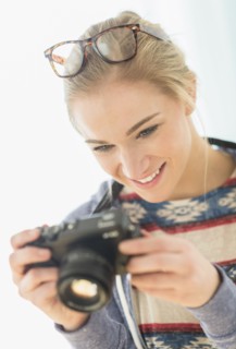 Woman taking picture with vintage camera.