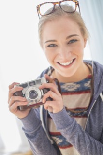 Portrait of woman holding vintage camera.
