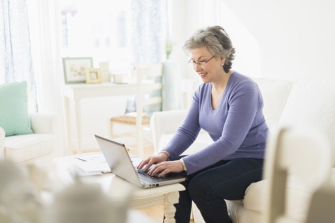 Mature woman paying bills via internet.