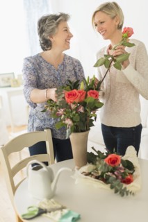 Two women arranging bouquet.
