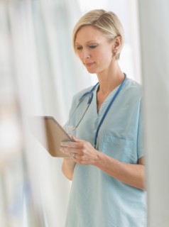 Female nurse using tablet PC.