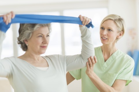Mature woman exercising with personal trainer.