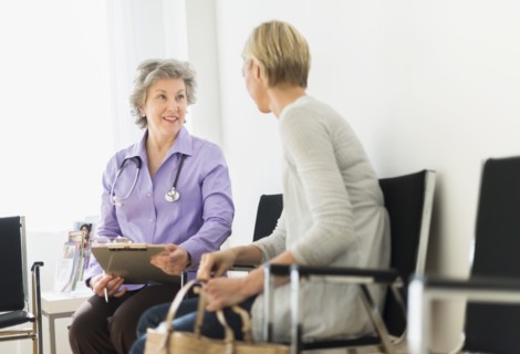 Doctor talking to patient in waiting room.