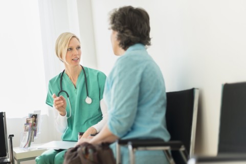 Doctor talking to patient in waiting room.