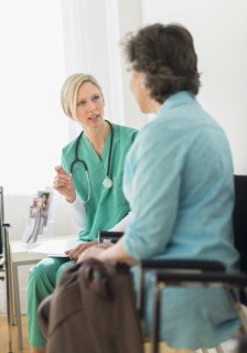Doctor talking to patient in waiting room.
