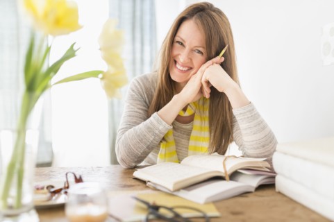 Portrait of smiling woman sitting at desk.