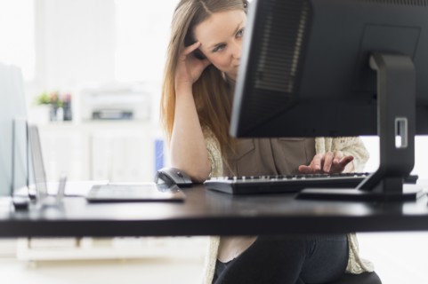 Portrait of young woman working on computer in office.