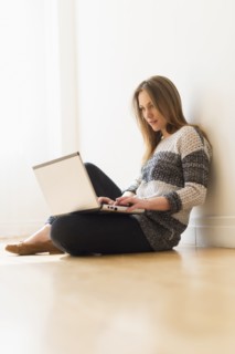Portrait of young woman using laptop.
