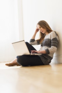 Portrait of young woman using laptop.