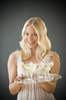 Portrait of young woman holding tray with champagne.
Photo : Jamie Grill