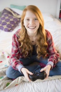 Portrait of girl (12-13) playing video games.
Photo : Jamie Grill