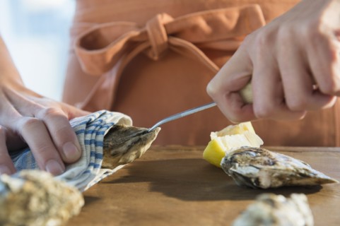 Woman shucking oysters.
Photo : Jamie Grill