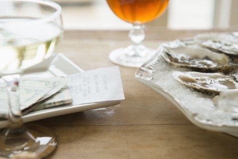 Studio shot of oysters, champagne and bill.
Photo : Jamie Grill
