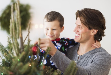 Man with kid (6-7) decorating Christmas tree.
Photo : Daniel Grill