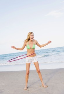 Young woman on beach twirling Hula hoop. Jupiter, Florida, USA.
Photo : Daniel Grill