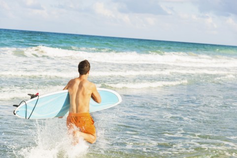 Young man carrying surfboard. Jupiter, Florida, USA.
Photo : Daniel Grill