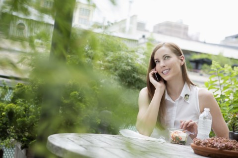 Portrait of young woman sitting on balcony and using mobile phone. New York City, USA.
Photo :