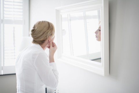 Woman applying make-up.
Photo : Mark de Leeuw