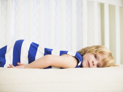 Girl (4-5) resting on bed.
Photo : Jessica Peterson