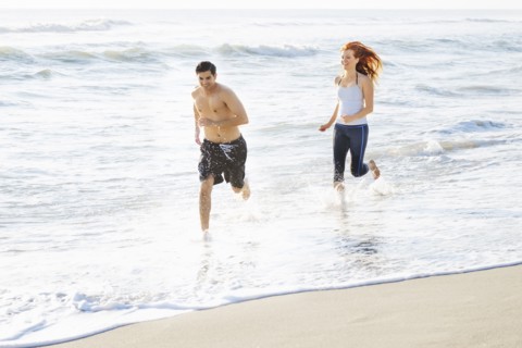Couple running on beach.