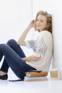 Portrait of young woman sitting on floor.