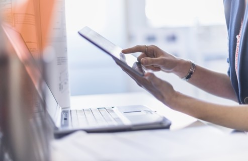 Close up of hands holding digital tablet.