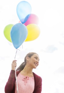 Young woman with colorful balloons.